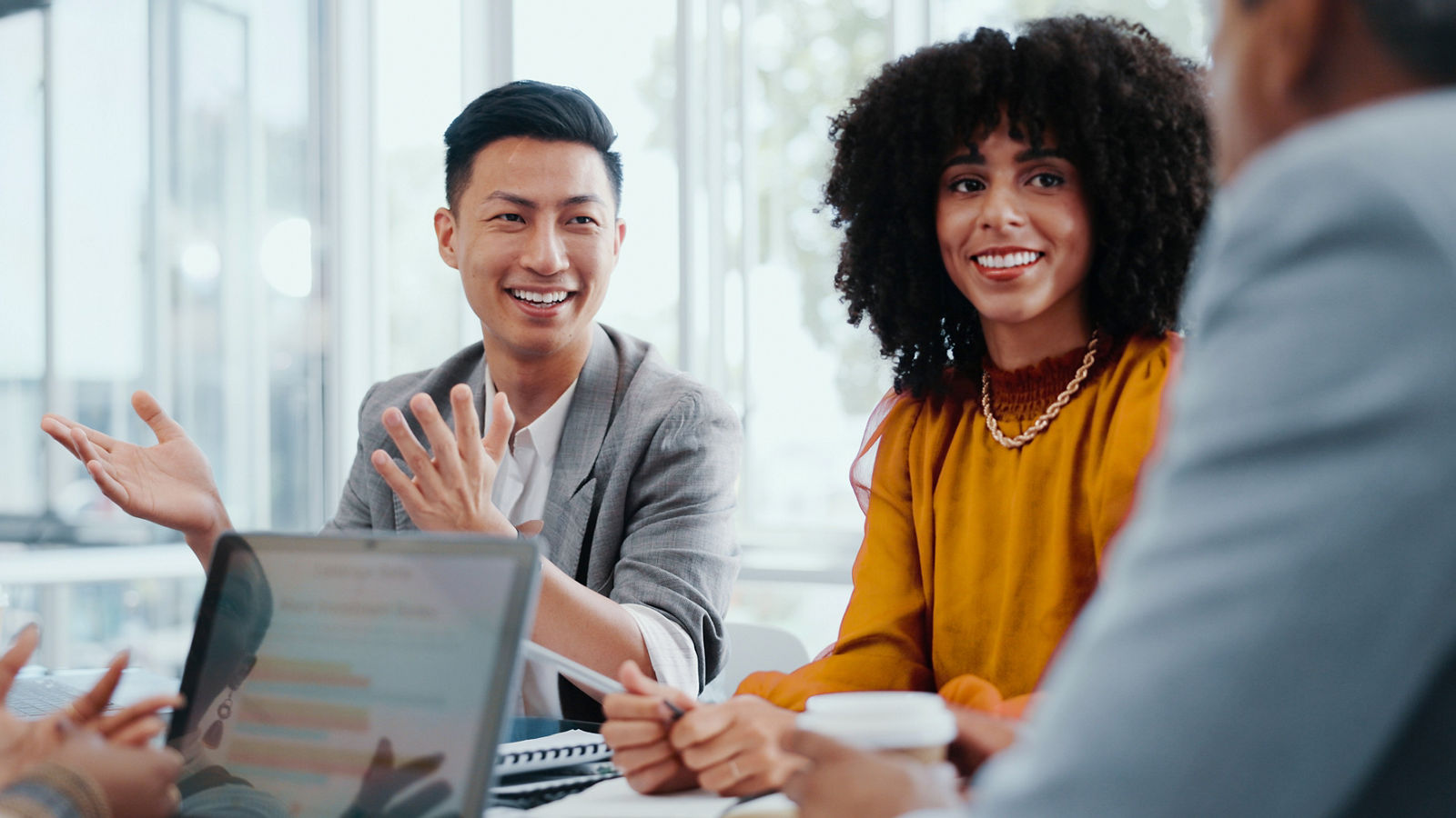 A picture of two sales workers discussing a proposal, smiling, across table