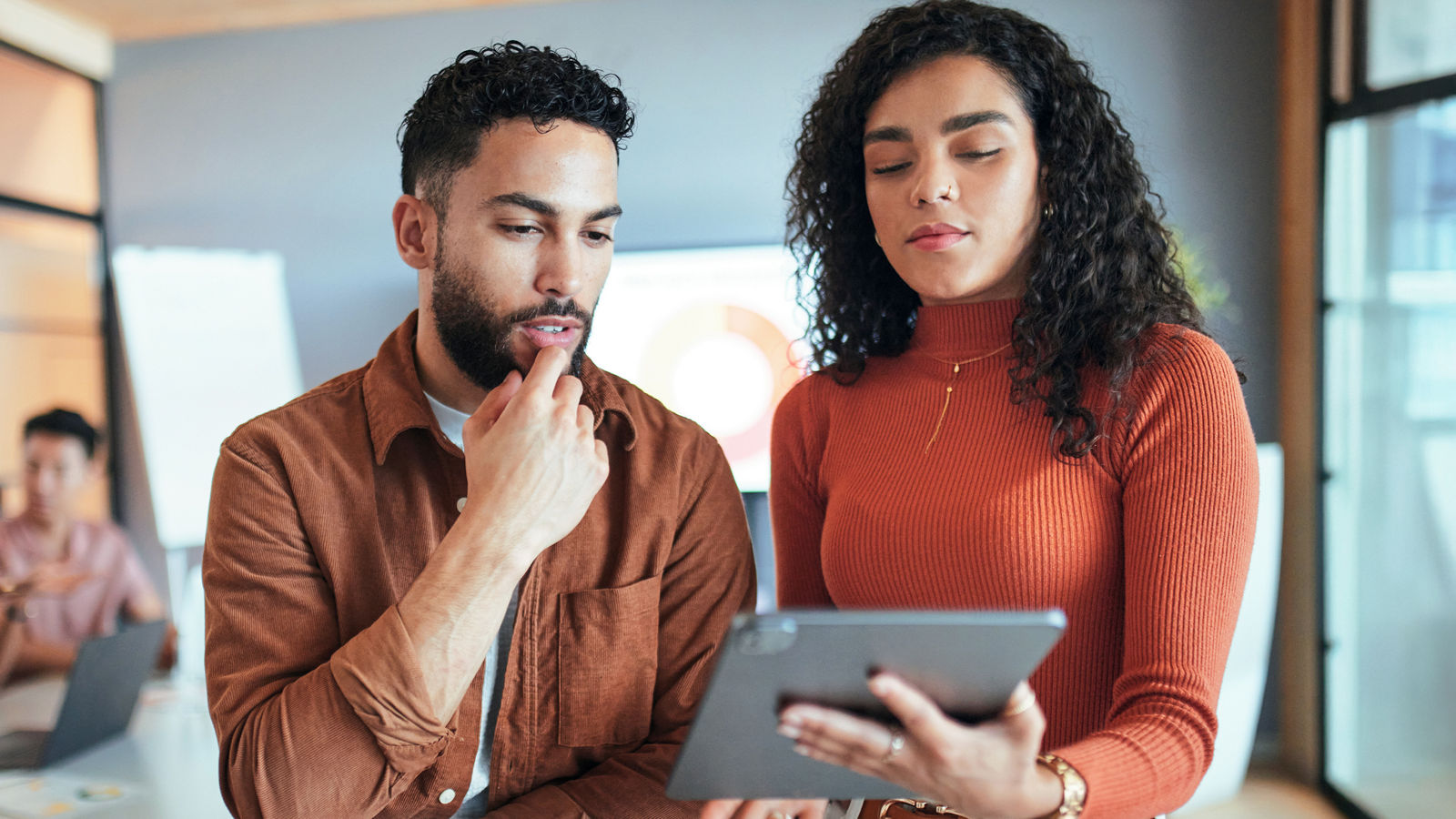 Two marketers looking at a tablet in an office, discussing IPPs.