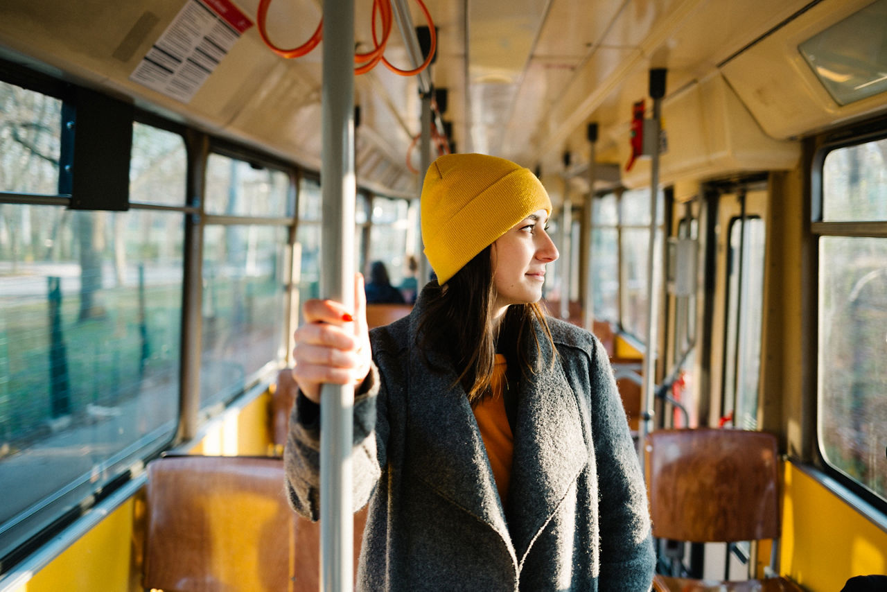 YOUNG WOMAN LOOKING THROUGH TRAIN WINDOW IN BUS