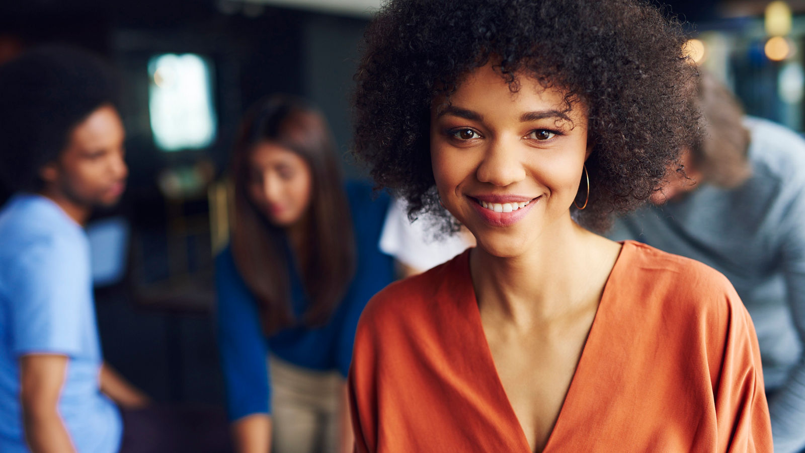 PORTRAIT OF SMILING YOUNG WOMAN