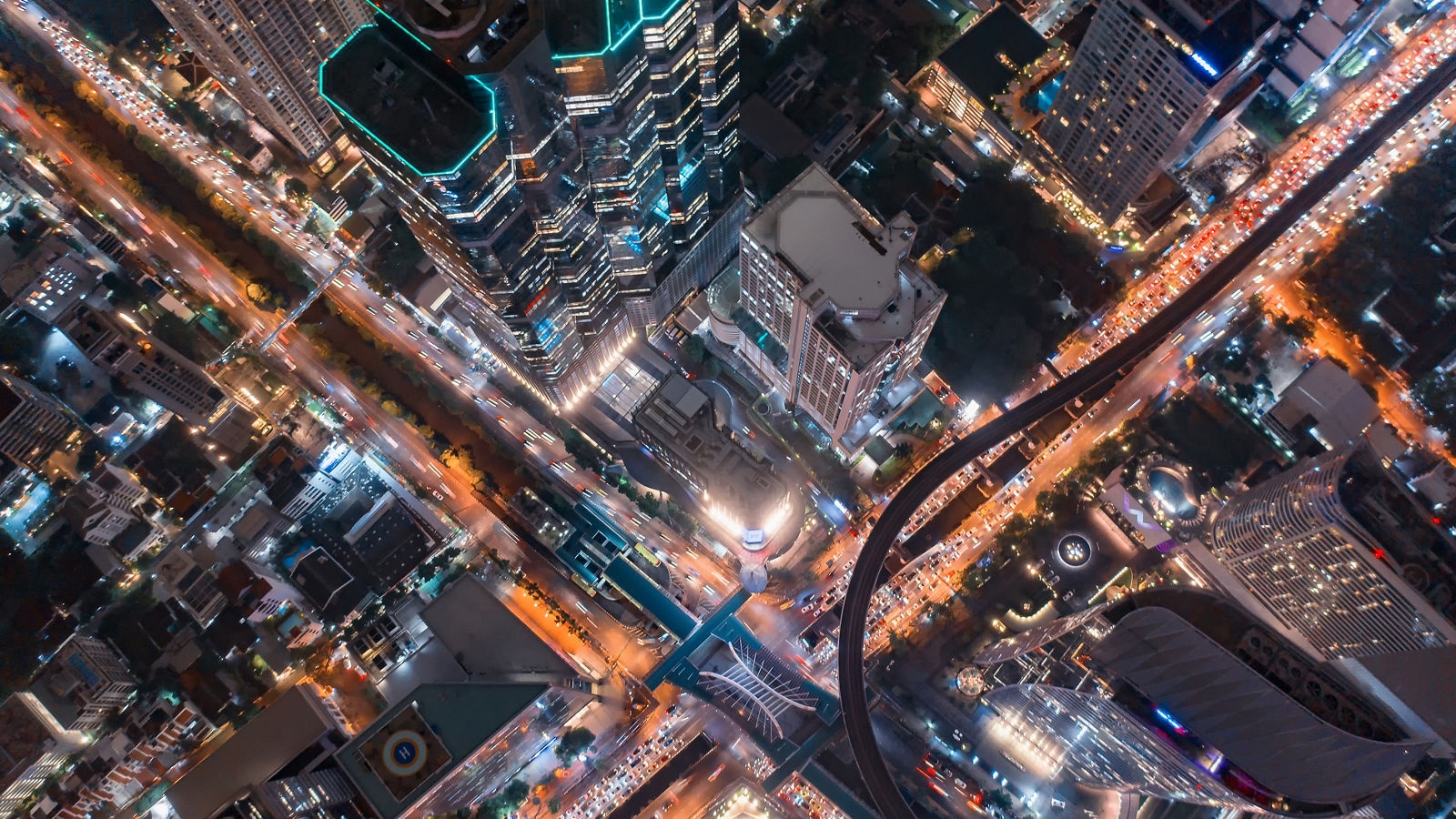 HIGH ANGLE VIEW OF ILLUMINATED CITY STREET AND BUILDINGS