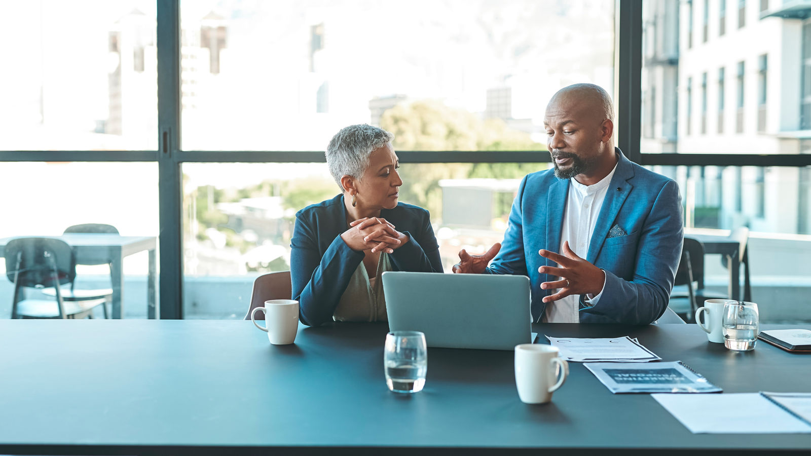 Two people discussion business content on a laptop