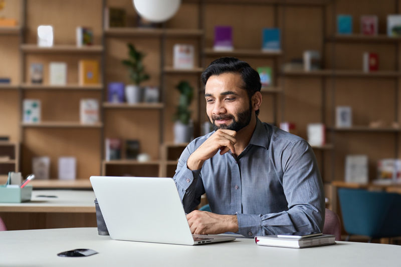 Smiling businessman working on laptop
