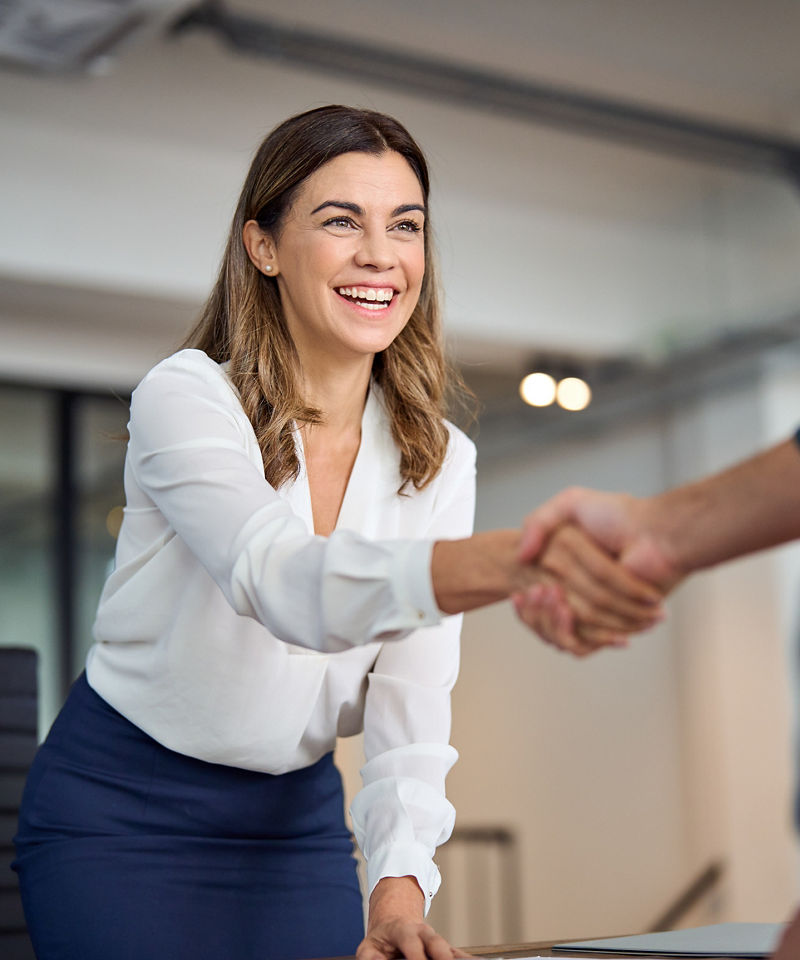 Happy business woman greeting client in office.