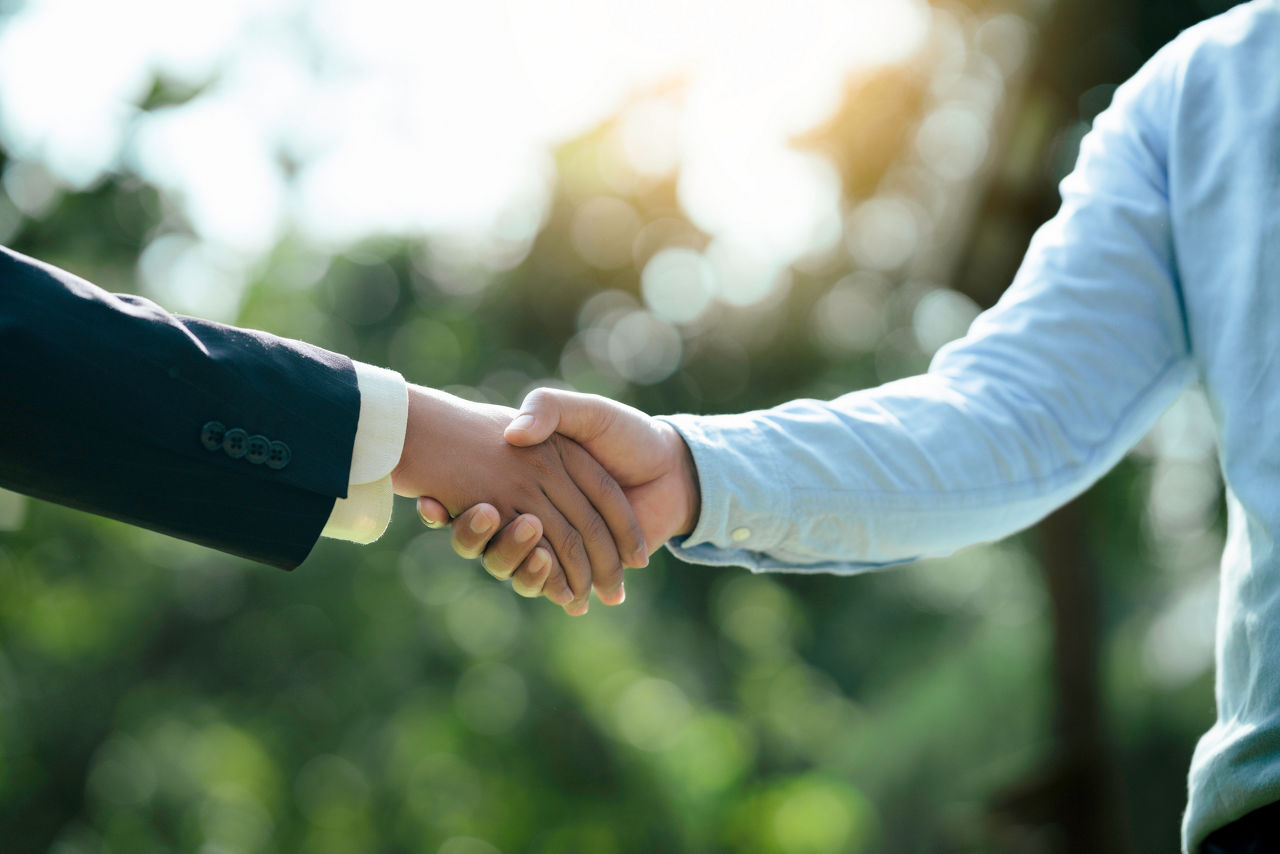 Businessmen shaking hands outside