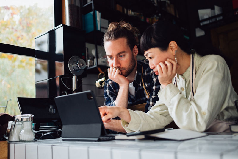 two small business employees looking at a tablet