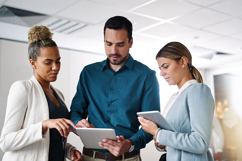 A group of businesspeople working on a digital tablet in an office
