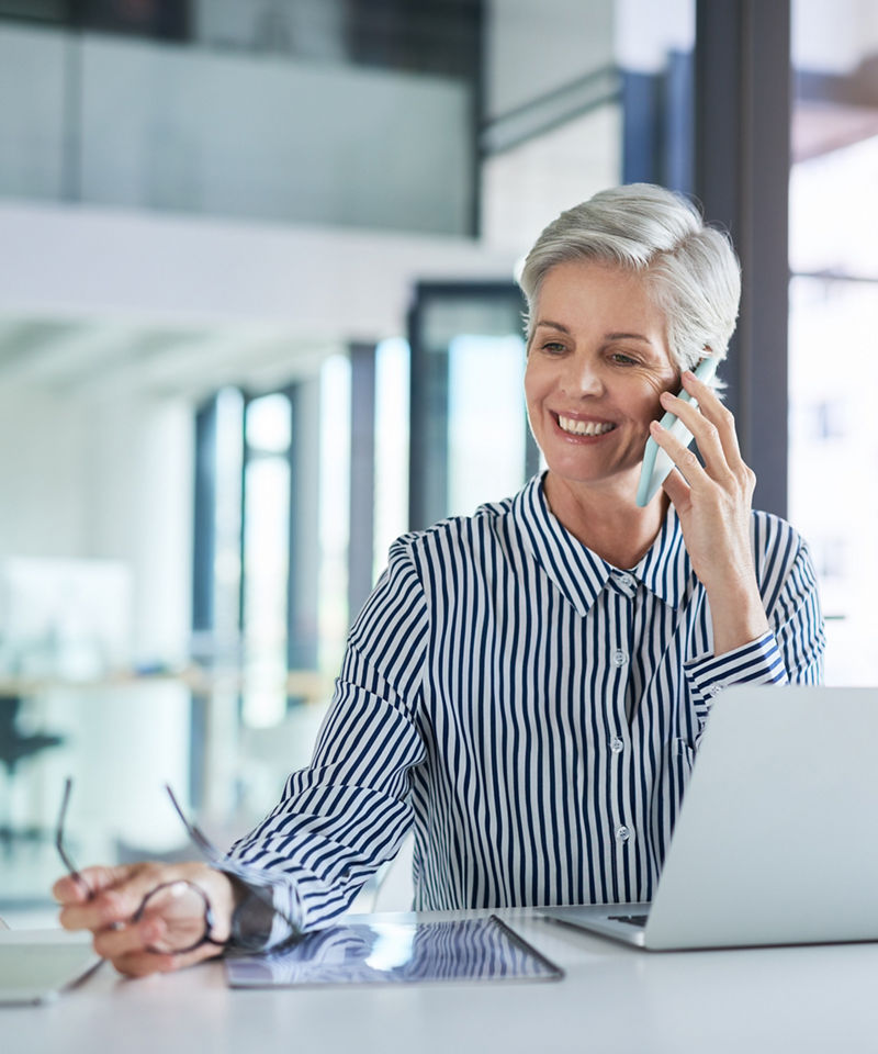 Businesswoman taking a phone call at her office desk