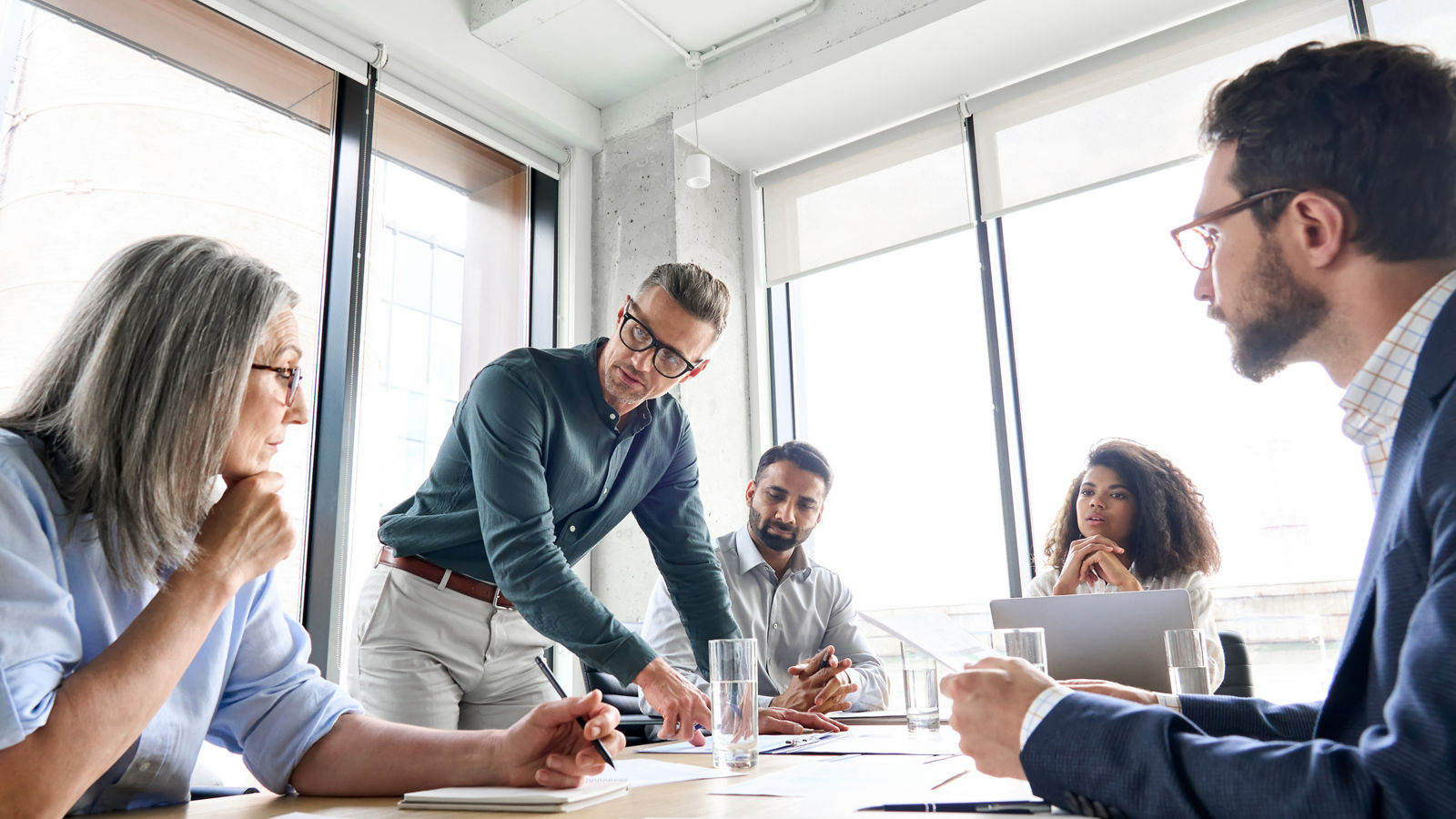 Male mature caucasian ceo businessman leader with diverse coworkers team, executive managers group at meeting. Multicultural professional businesspeople working together on research plan in boardroom.; Shutterstock ID 2142010187; purchase_order: 2024-10; job: Guide; client: ; other: 