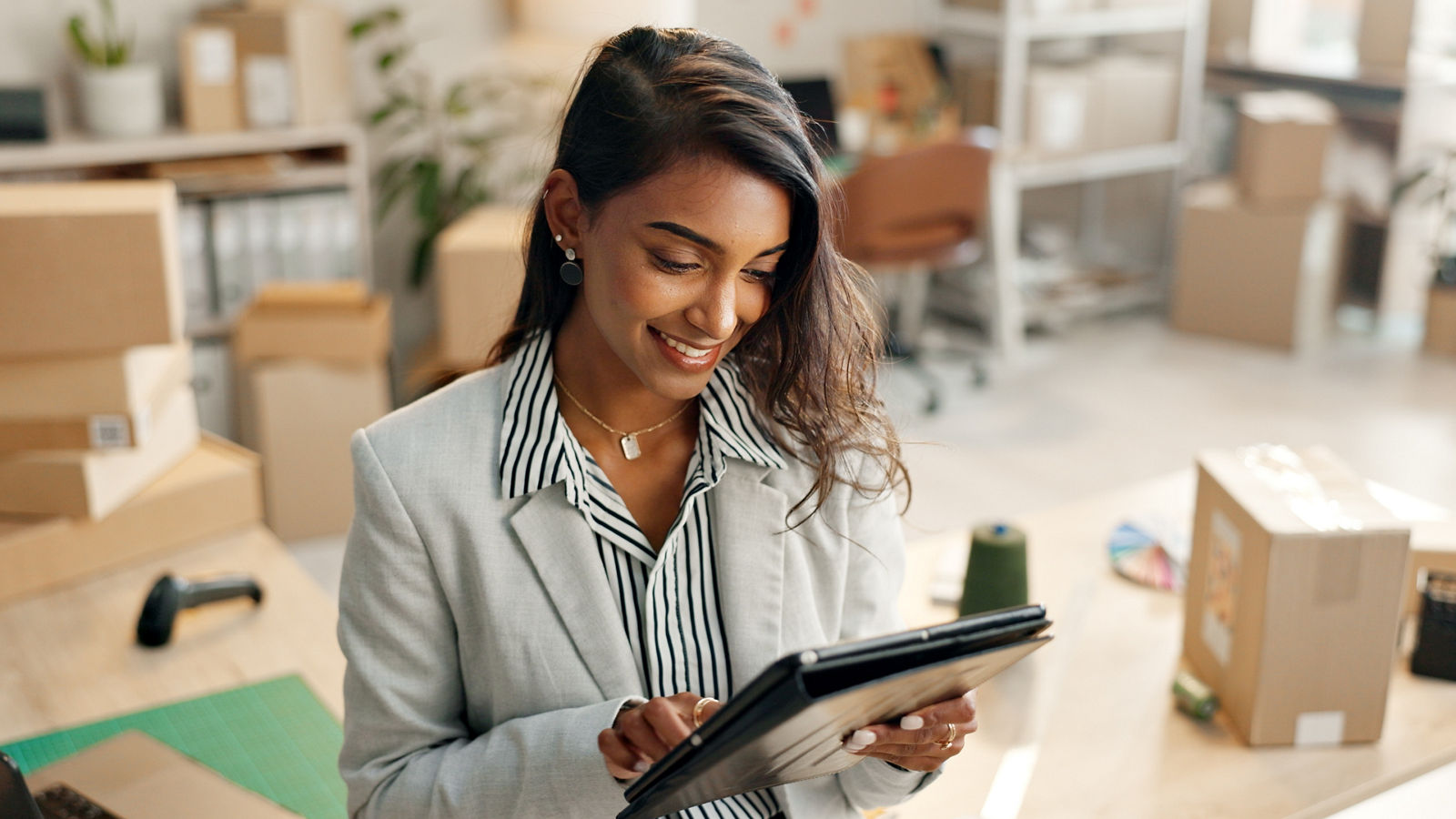 Small business, woman and boxes with tablet, e commerce and startup inventory management for online shop, order or courier. Entrepreneur or young seller on digital technology for logistics or package; Shutterstock ID 2377314493; purchase_order: 2024-10; job: Guide; client: ; other: 
