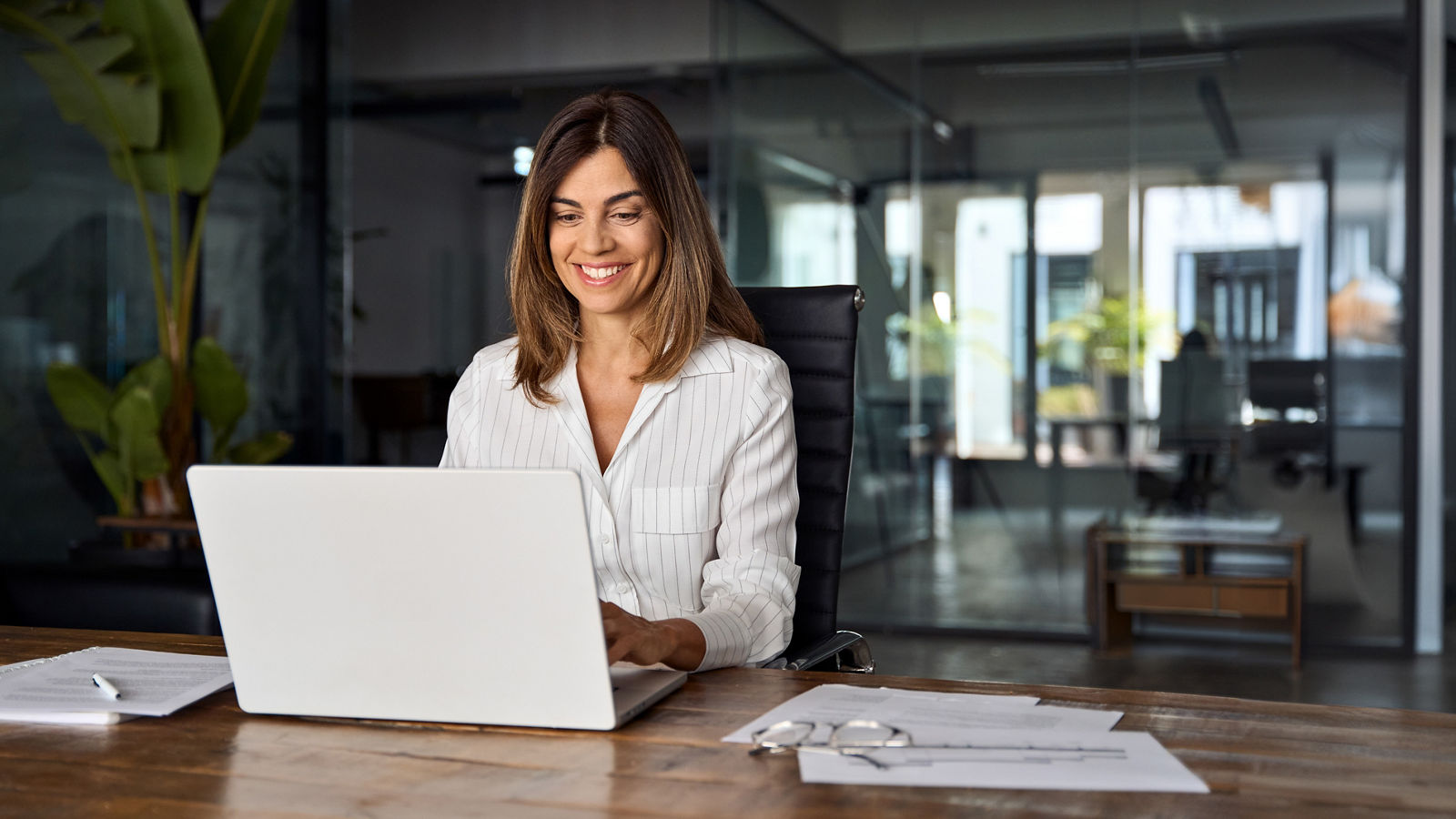 Middle age European business woman CEO using laptop application for work at table workspace in office. Smiling Latin Hispanic mature adult professional businesswoman using pc digital computer. Banner; Shutterstock ID 2488640771; purchase_order: 2024-10; job: Guide; client: ; other: 