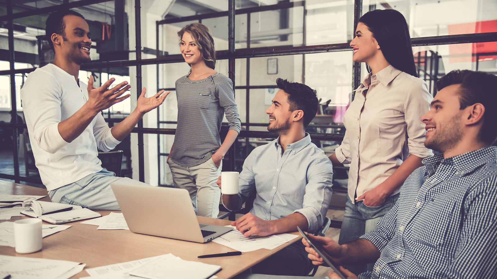 Beautiful business people are using gadgets, talking and smiling during the conference in office