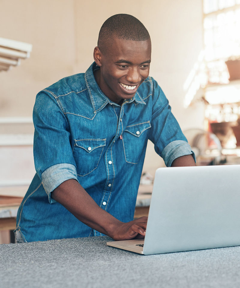 Smiling renovation worker using his laptop on jobsite