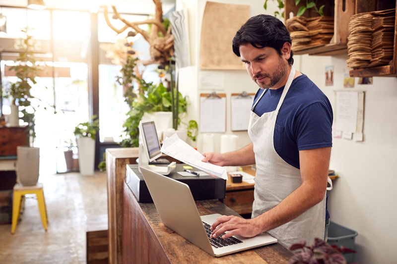 Small business owner looking at laptop confused