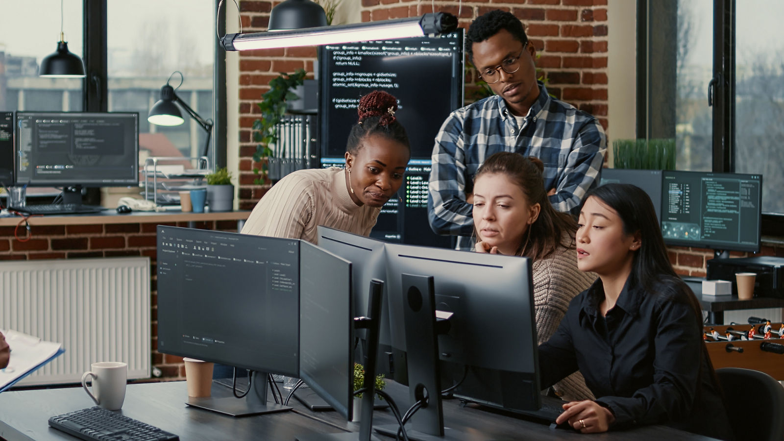 Software engineers brainstorming ideas looking at code on computer screens