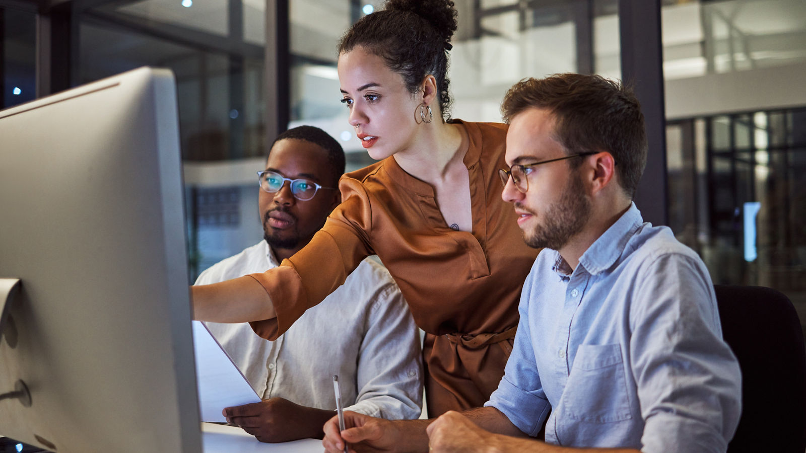 Data analysts looking at computer screen in office