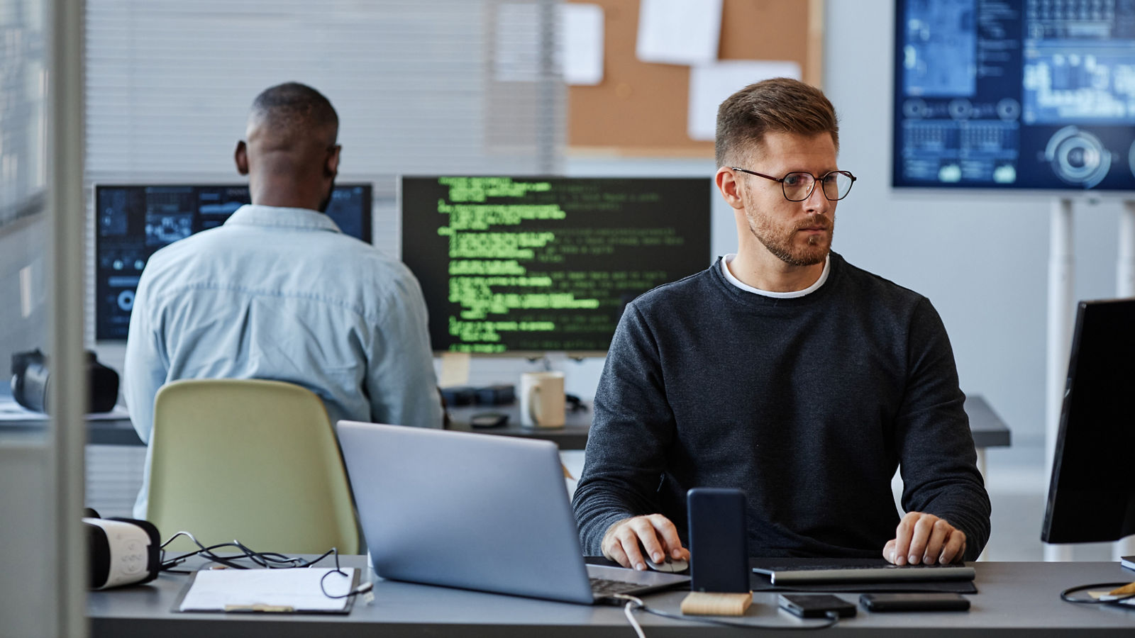 Data analyst looking at computer screen in office
