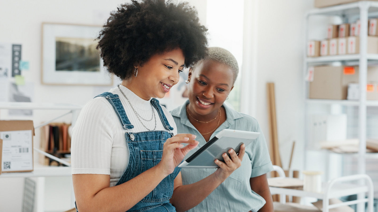 Small business owner women looking at tablet together