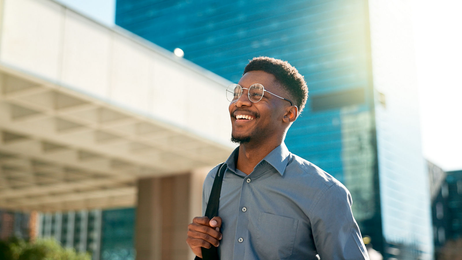 Business, happy and walking black man on city journey, commute trip and realtor smile on way to office building. Happiness, career expert and African real estate agent on morning travel in Nigeria.