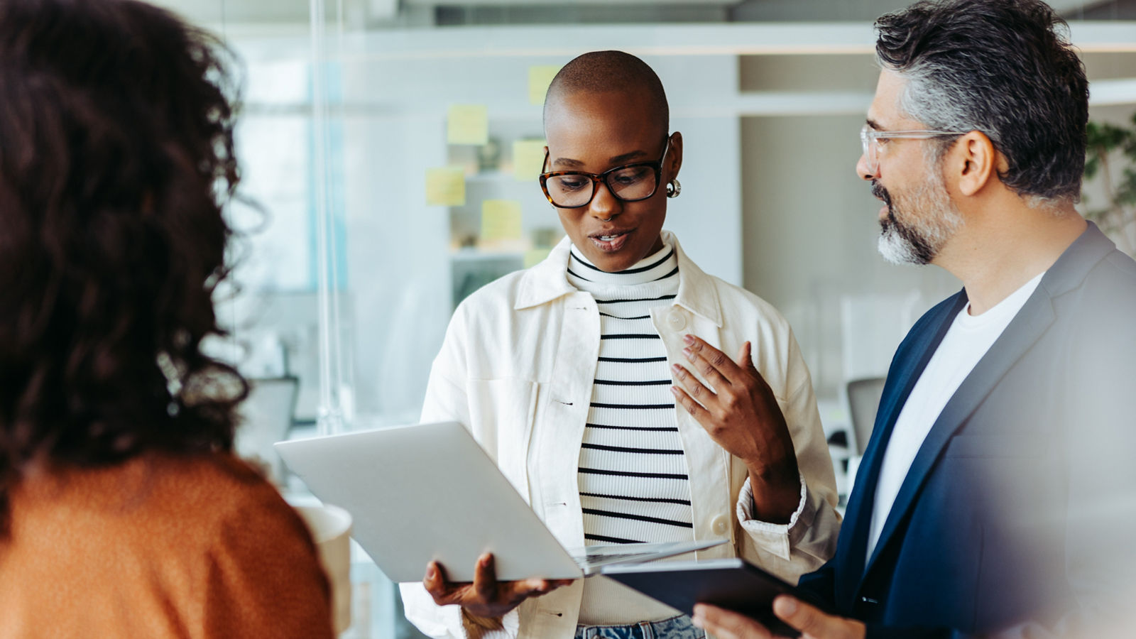Young business woman engaging her colleagues in a collaborative discussion during a meeting. Group of business people working together towards a common goal of corporate success.