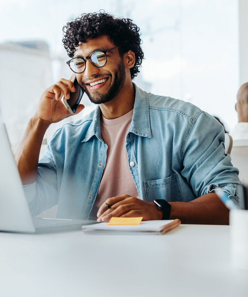 Business man smiling on laptop on phone