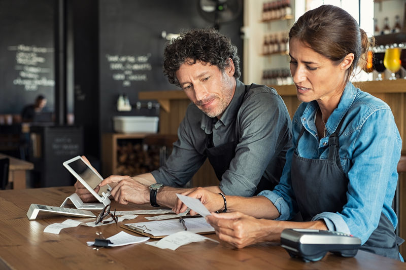 Man and woman sitting in counter discussing finance.