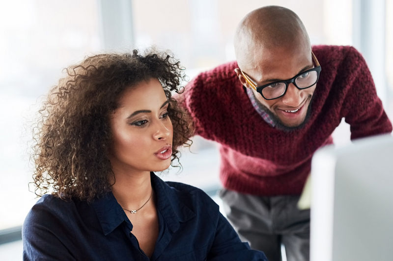 Cropped shot of a male supervisor helping an attractive young businesswoman while working in their office