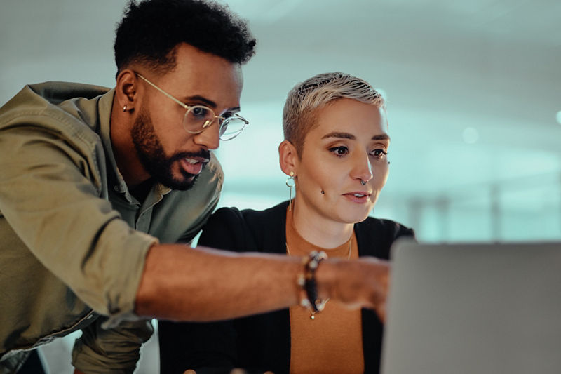Two programmers examine code at a computer
