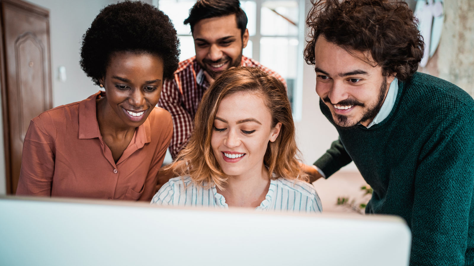 Shot of a group of colleagues using computer together at work
