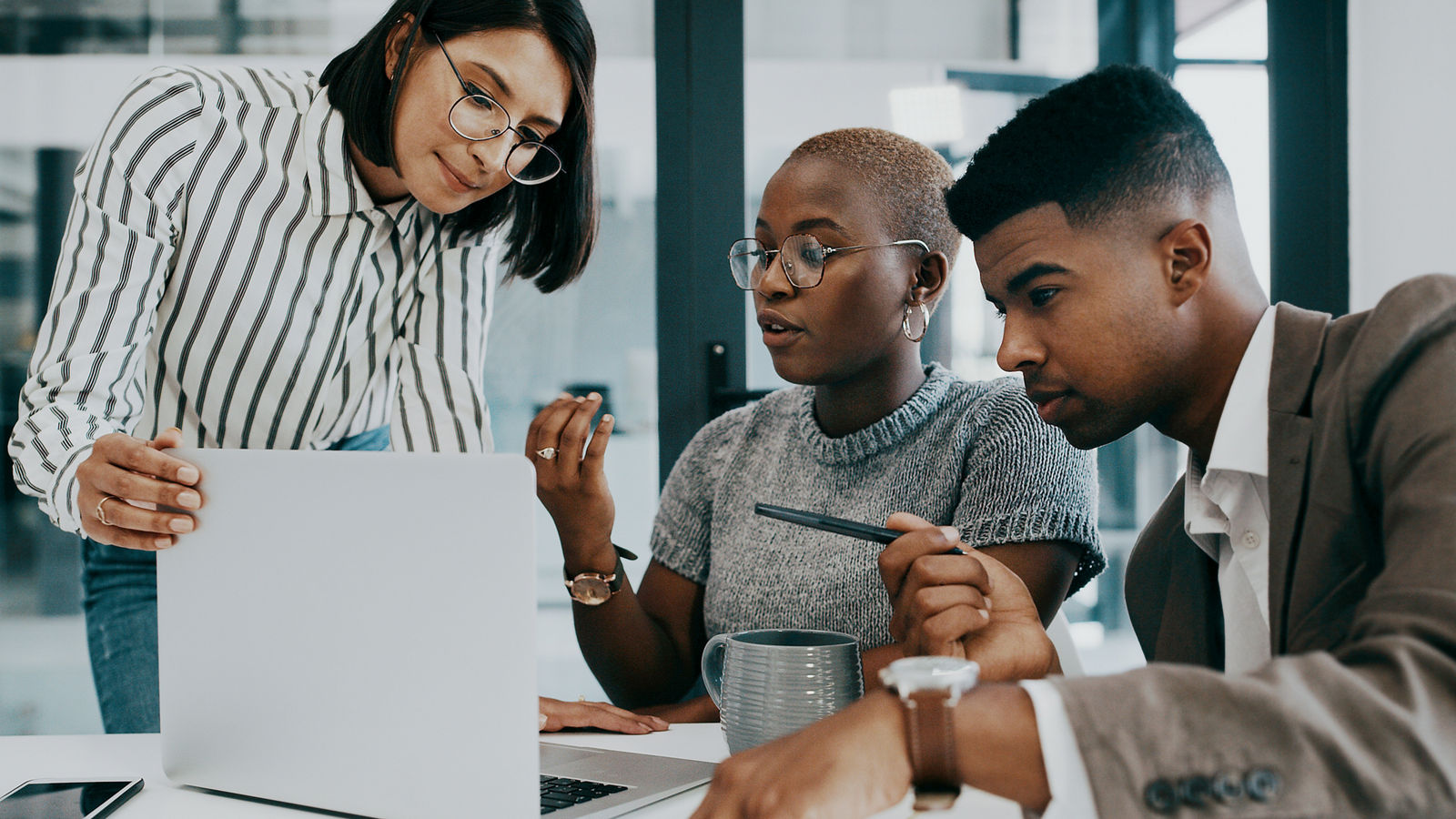 Shot of a group of businesspeople working together on a laptop in an office