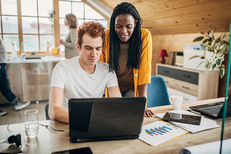 Startup business employees talking over laptop in small office