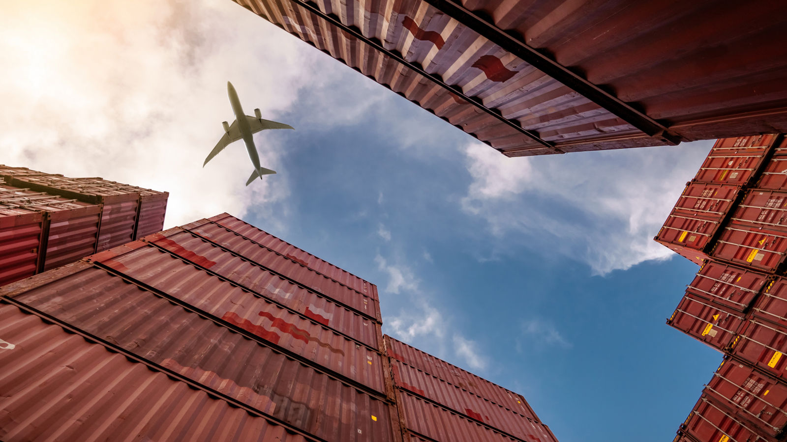 Airplane flying above container yard
