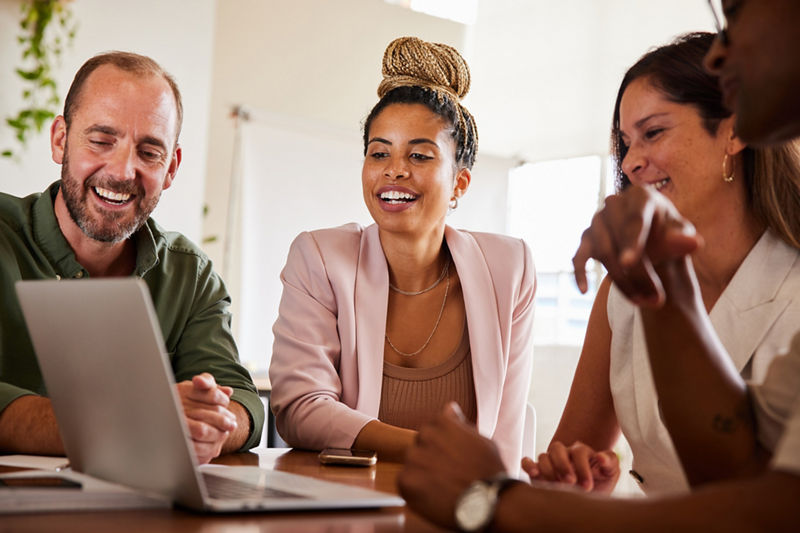 Business people on laptop in office smiling