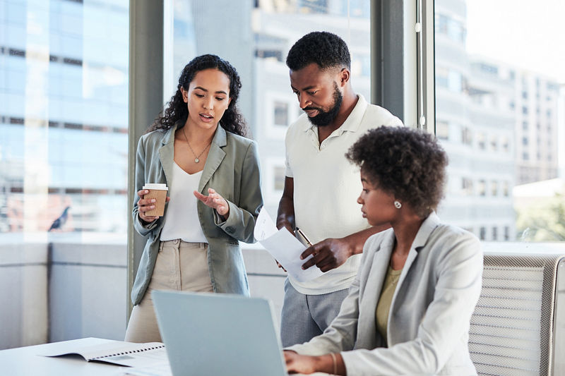 Group of workers discussing business finances over laptop