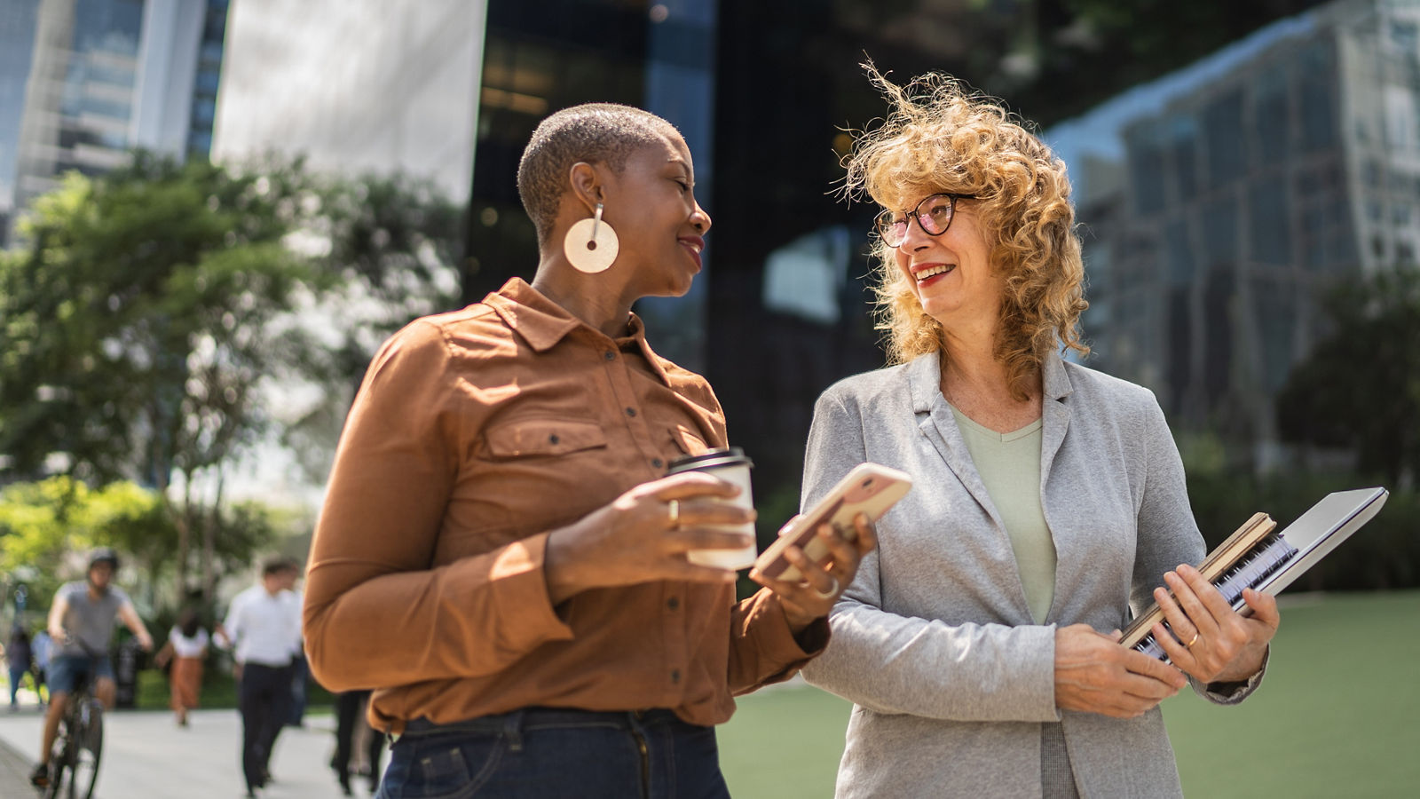 Business women talking while walking outdoors