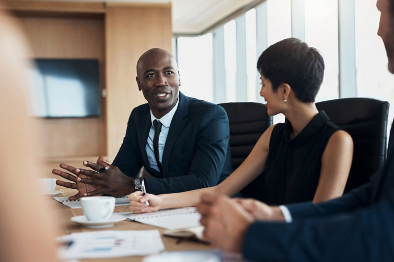 Business workers in office speaking around table