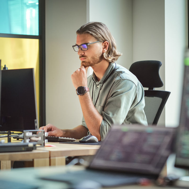 Focused Man Coding On Desktop Computer