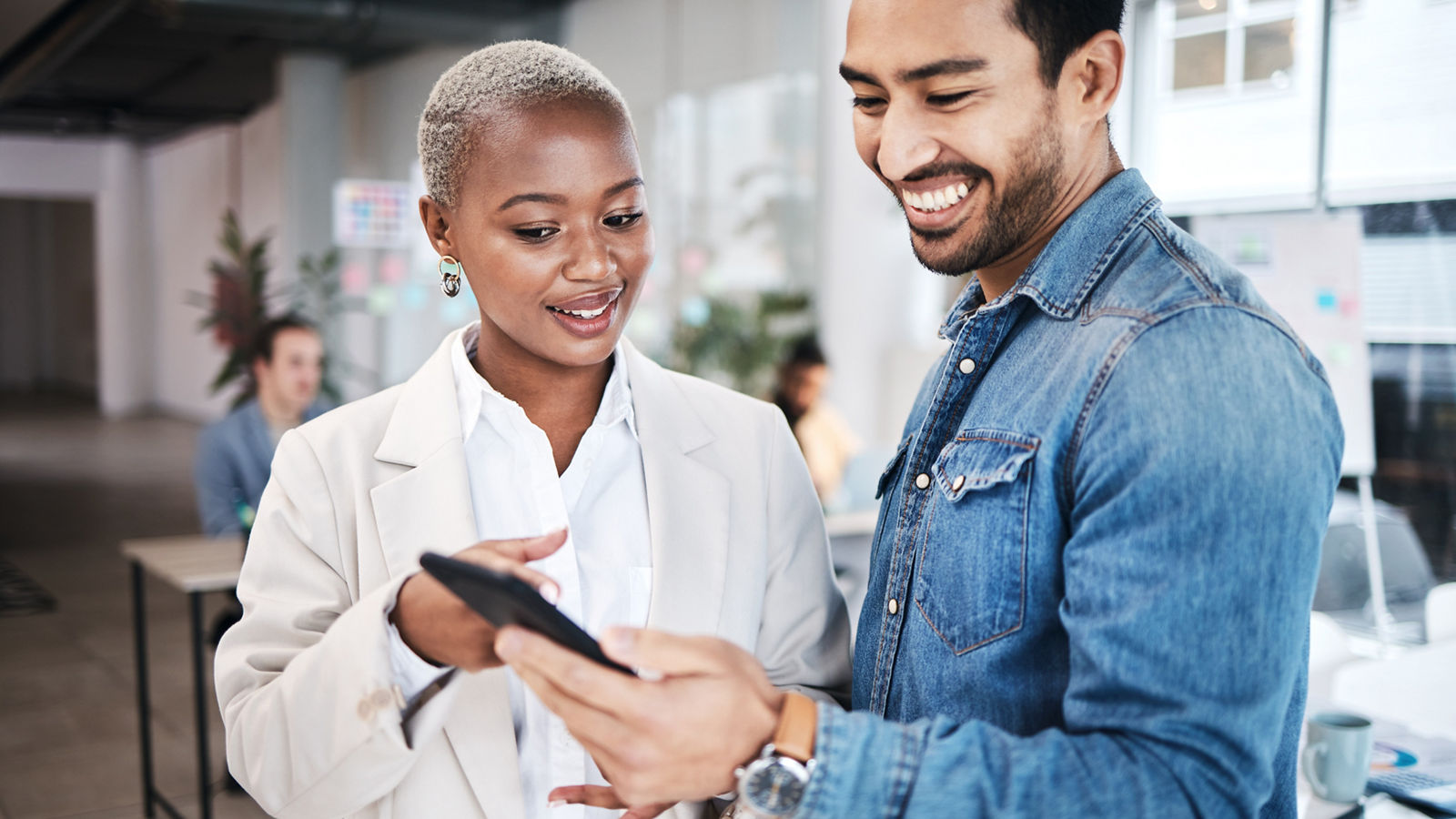 Two sales people looking over tablet discussing business plans