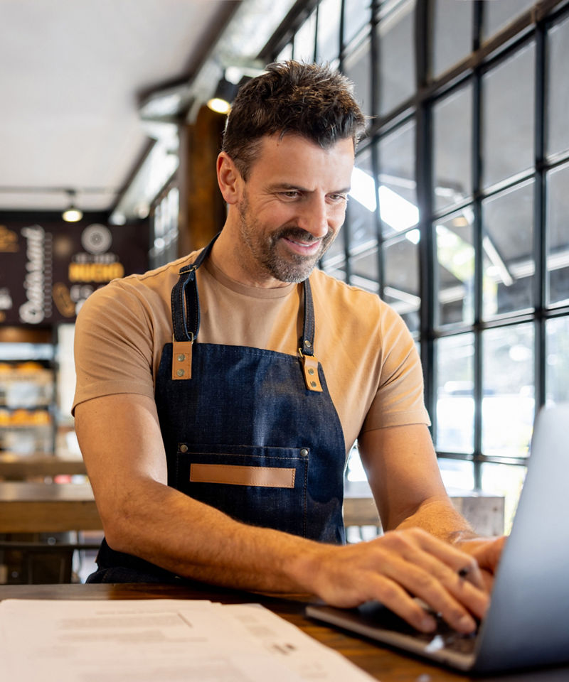 Business owner working on laptop inside of cafe business