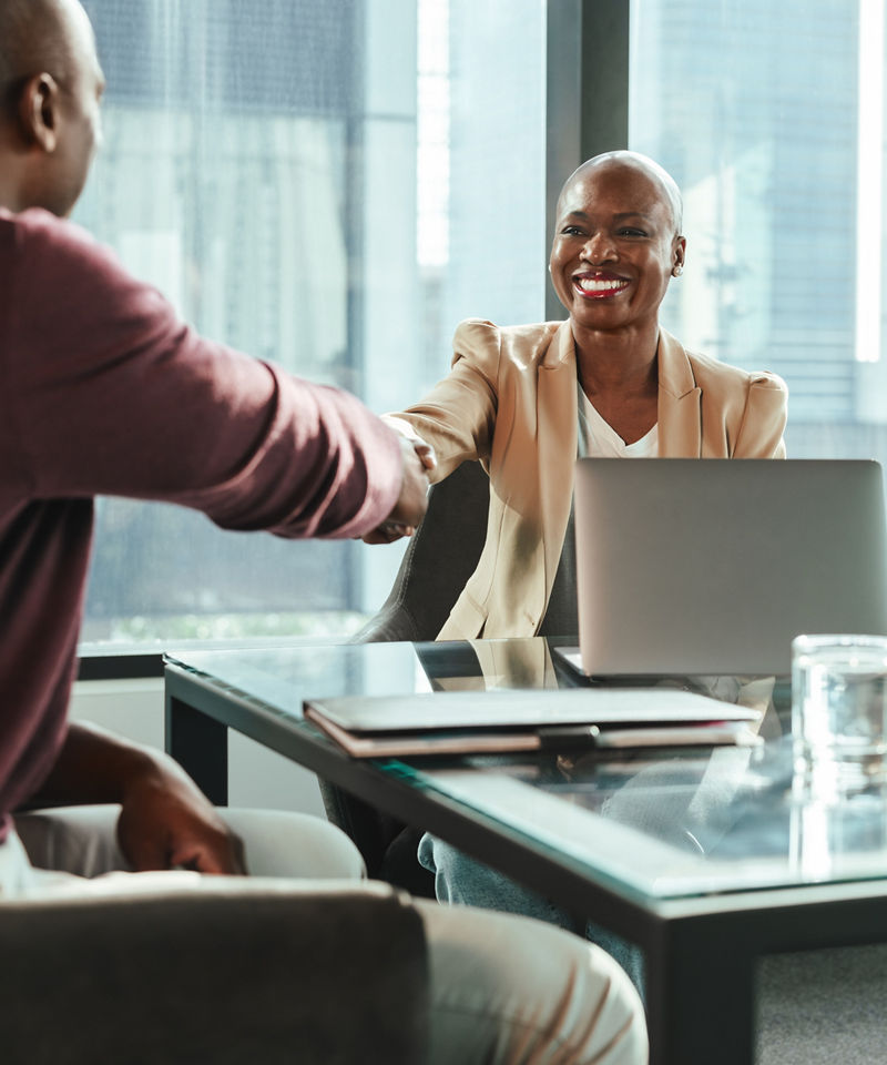 Business people in an office setting engage in a successful meeting, shaking hands.