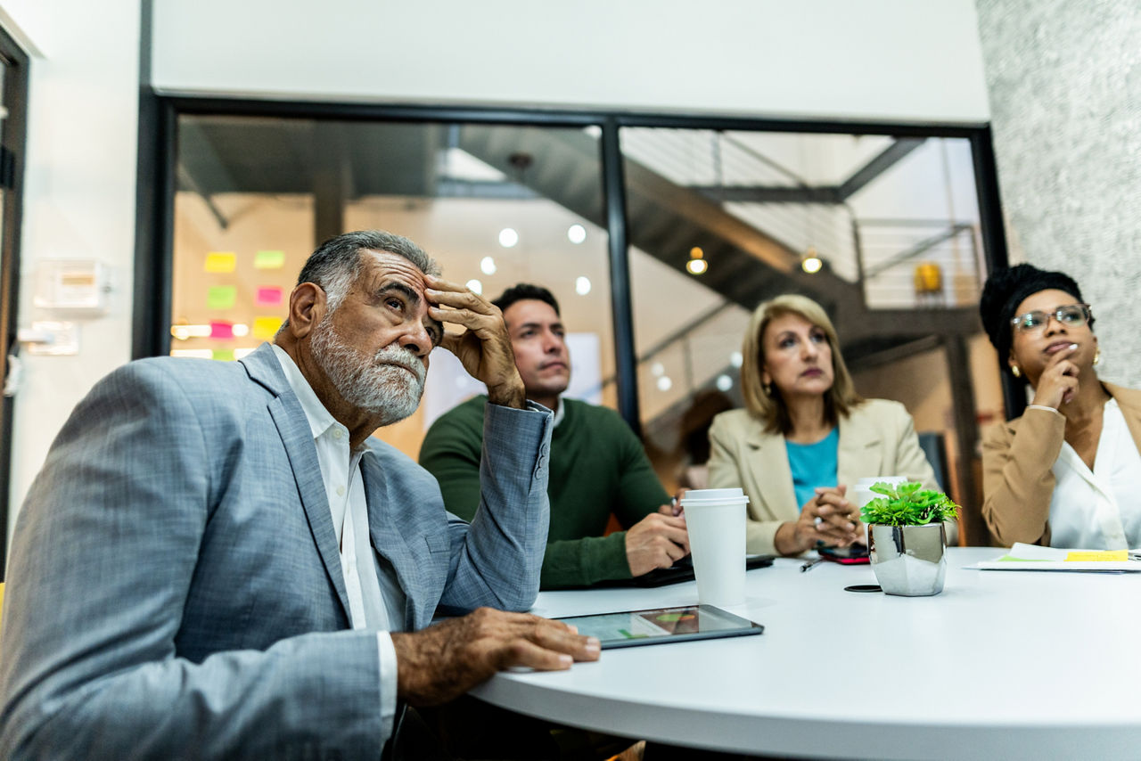 Concerned businesspeople listening in a meeting