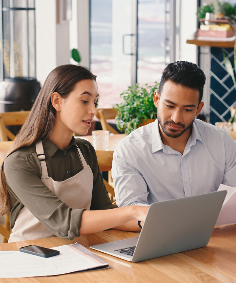 Woman, man and laptop in coffee shop for accounting with discussion