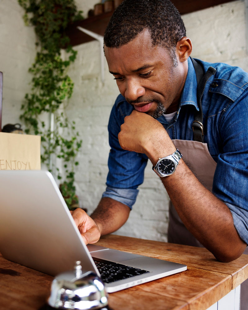 Man using laptop for online business order at bakehouse