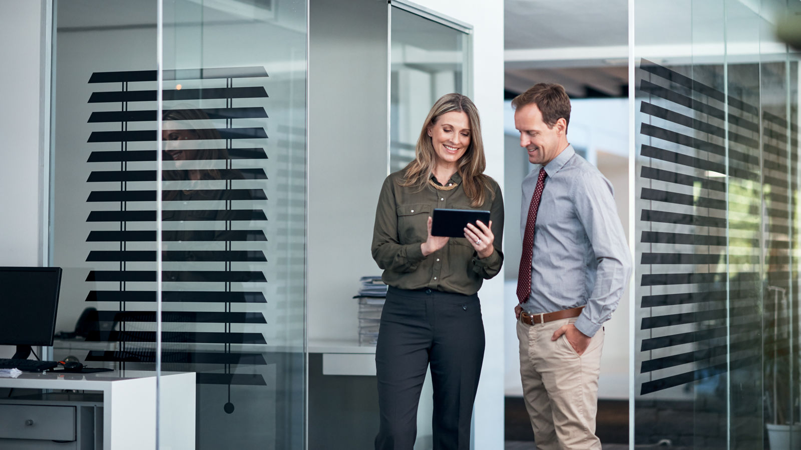 Two businesspeople using a digital tablet together in an office