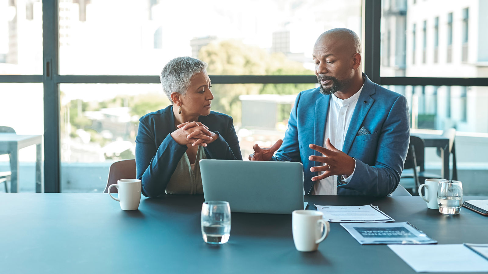 Two people discussion business content on a laptop