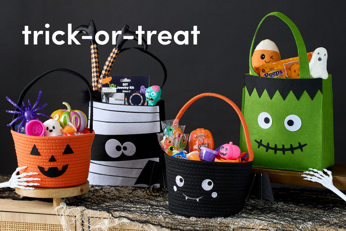 Pumpkin, mummy, bat and Frankenstein themed candy baskets are filled with various Halloween themed toys and decor.