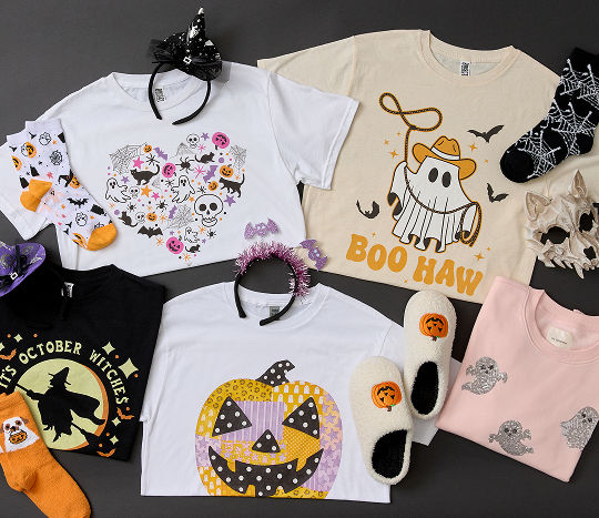 Affordable Halloween accessories including pumpkin slippers, themed masks and headbands, and spooky graphic tees are displayed neatly on dark flooring.