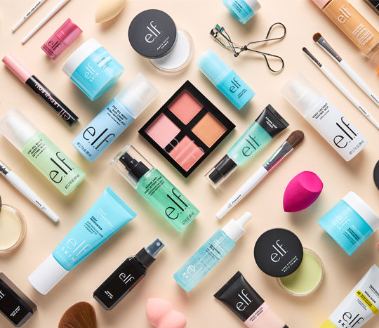 An assortment of e.l.f. products from pOpshelf is displayed against a neutral cream background.