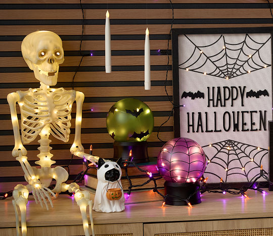 Light-Up Halloween decor; skeleton, sign, candles sitting on a side table