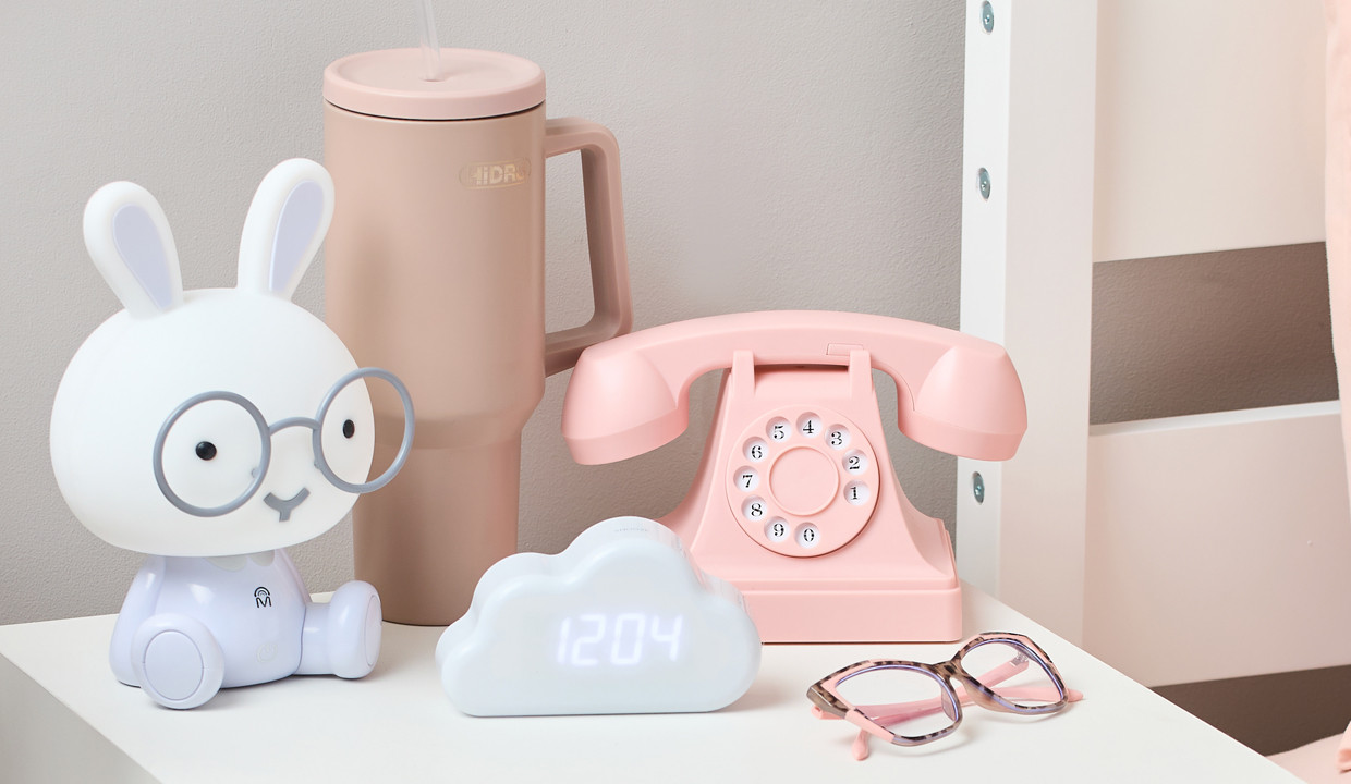 Back-to-school electronics: vintage pink telephone headset, bunny lamp, and whilte cloud-shaped digital clock.